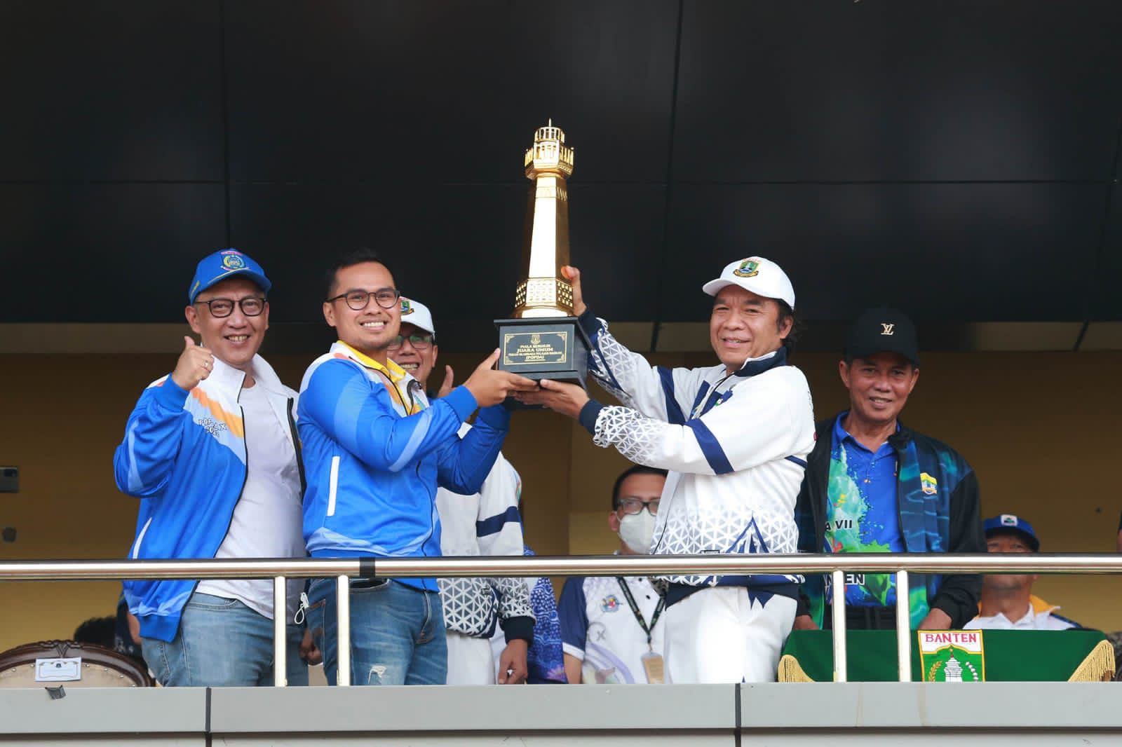 Pj Gubernur Banten Al Muktabar menyerahkan Piala Juara Umum kepada Wakil Wali Kota Tangsel Pilar Saga Ichsan. (Dok. Humas Pemprov Banten)