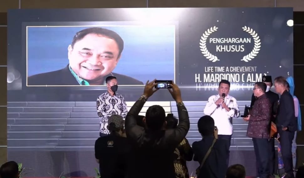 Rivo Derry saat menerima penghargaan khusus Life Time A Chievement untuk Almarhum H. Margiono atas dedikasi nya sebagai Tokoh pendiri Kota Tangsel dan juga sebagai tokoh Pers Nasional. (tangselpo.id/irw)