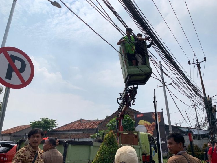 Dinas SDABMBK Kota Tangerang Selatan saat merelokasi sejumlah kabel fiber optik yang semrawut di sepanjang Jalan Ceger Raya, Pondok Aren, Tangerang Selatan, Jumat (15/7/2022). Foto : Istimewa