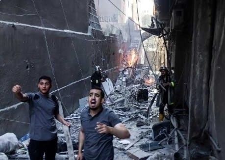 Terus Gempur Gaza, Bunuh Anak-anak 2 Pria Palestina berlarian untuk menolong koran anak-anak dari gempuran pasukan Israel. (Ist)