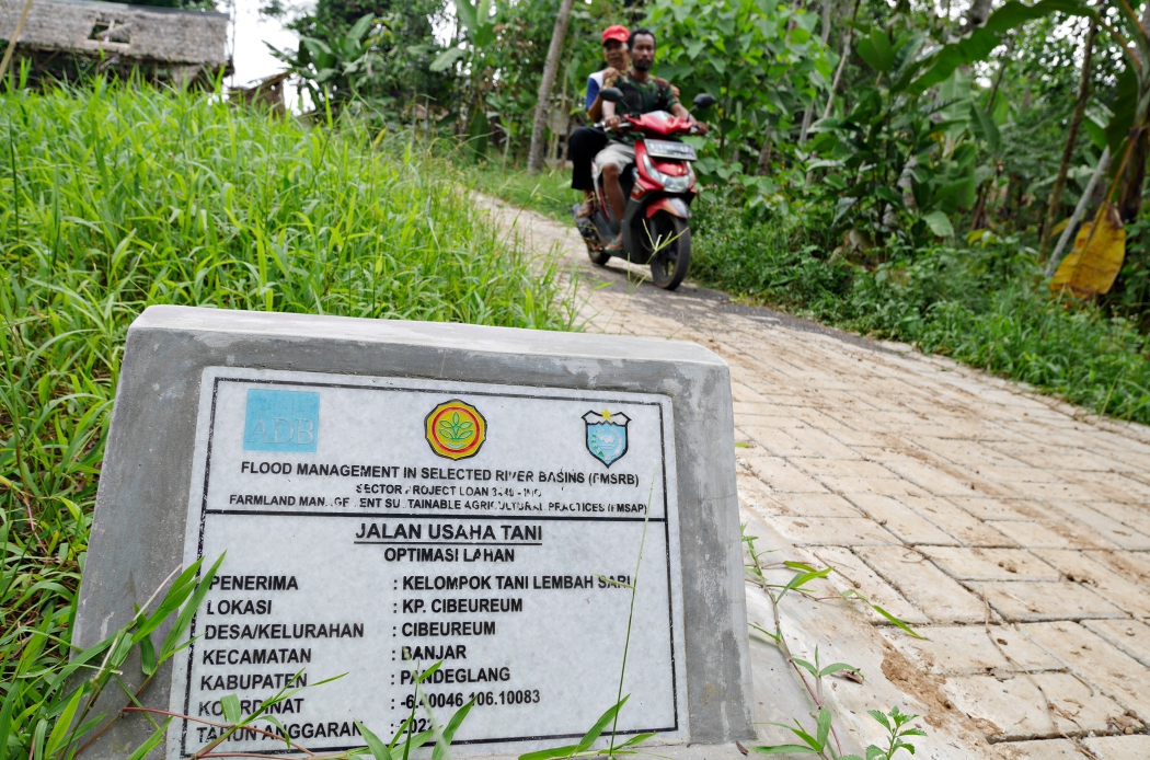 Warga melintas di Jalan Usaha Tani (JUT) di Kampung Cibeureum, Desa Cibodas, Kecamatan Banjar, Pandeglang, Selasa (20/9/2022).(Ari Supriadi/Tangsel Pos)