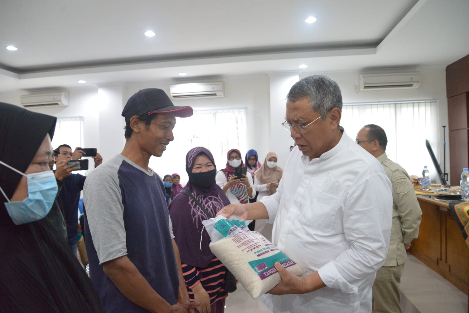 Wali Kota Tangsel, Benyamin Davnie menyerahkan bantuan kepada masyarakat di Kelurahan Bakti Jaya, Setu, Tangsel, Jumat (25/11/2022). (tangselpos.id/rmn)