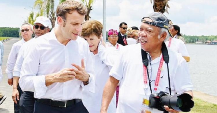 Menteri PUPR Basuki Hadimuljono dengan gayanya menenteng kamera saat berbincang dengan Presiden Prancis Emmanuel Marcon. (Ist)