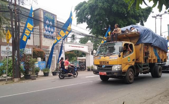 Masih ada petugas kebersihan Kota Tangerang yang nekat naik diatas truk sampah.