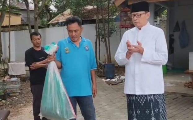 Wahidin Halim saat memperlihatkan karung yang berisi ular kobra. (Ist)