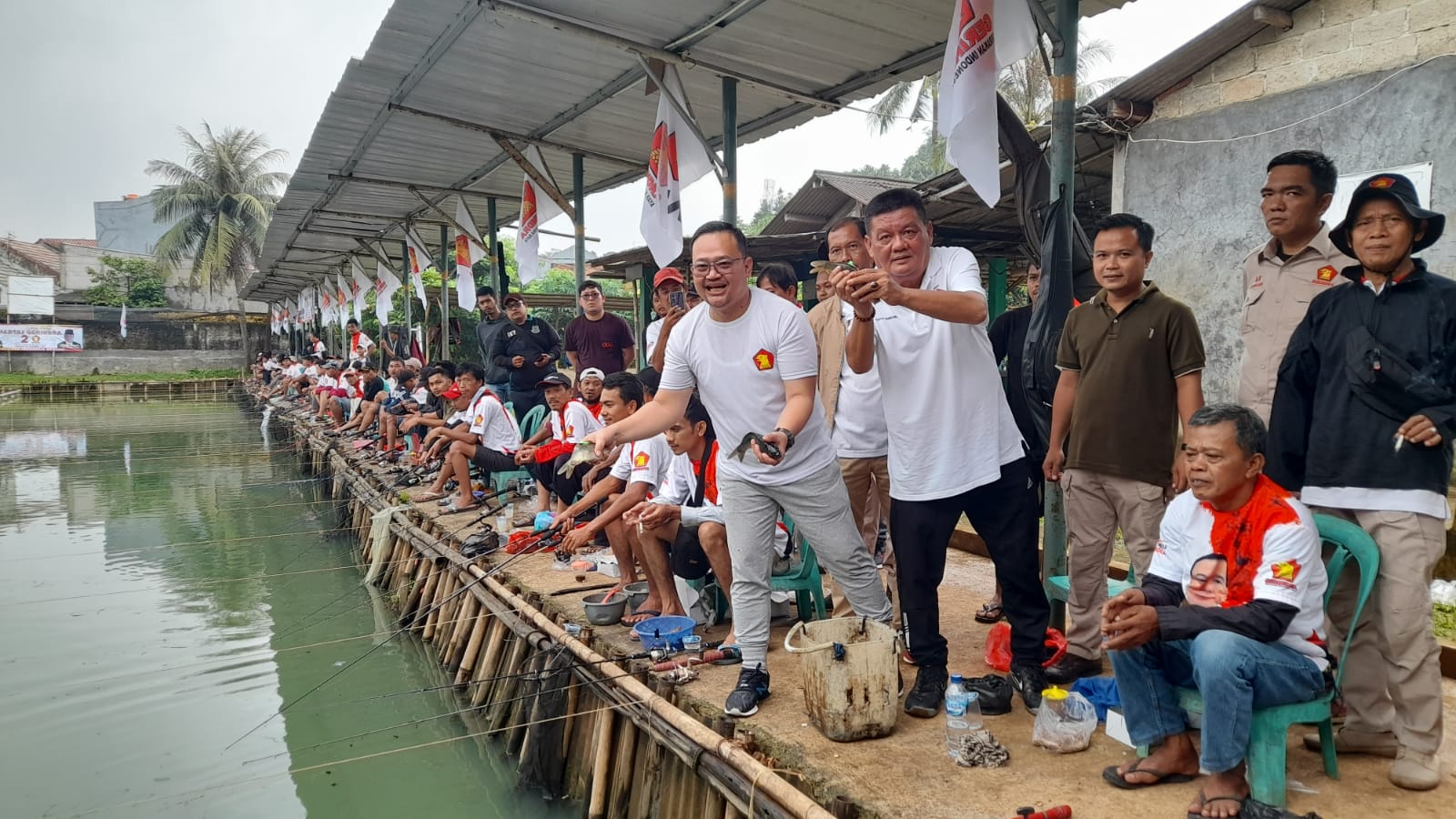 Melihat Peringatan HUT Ke-15 Partai Gerindra Di Tangsel Wakil Ketua DPC Gerindra Tangsel Arnovi dan Sekretaris Gerindra Tangsel, Yudi Budi Wibowo saat mancing bareng bersama kader dan loyalis partai di Pamulang Timur, Kecamatan Pamulang.