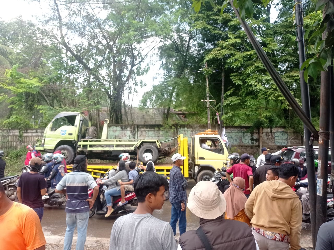 Petugas Dinas Lingkungan Hidup (DLH) Kota Tangsel langsung melakukan evakuasi dan pembersihan terhadap sisa sampah yang diakbat truk sampah terguling, Minggu (14/4). (dra)