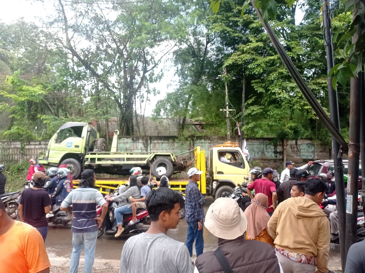Truk Pengangkut Sampah Terguling Petugas Dinas Lingkungan Hidup (DLH) Kota Tangsel langsung melakukan evakuasi dan pembersihan terhadap sisa sampah yang diakbat truk sampah terguling, Minggu (14/4). (dra)