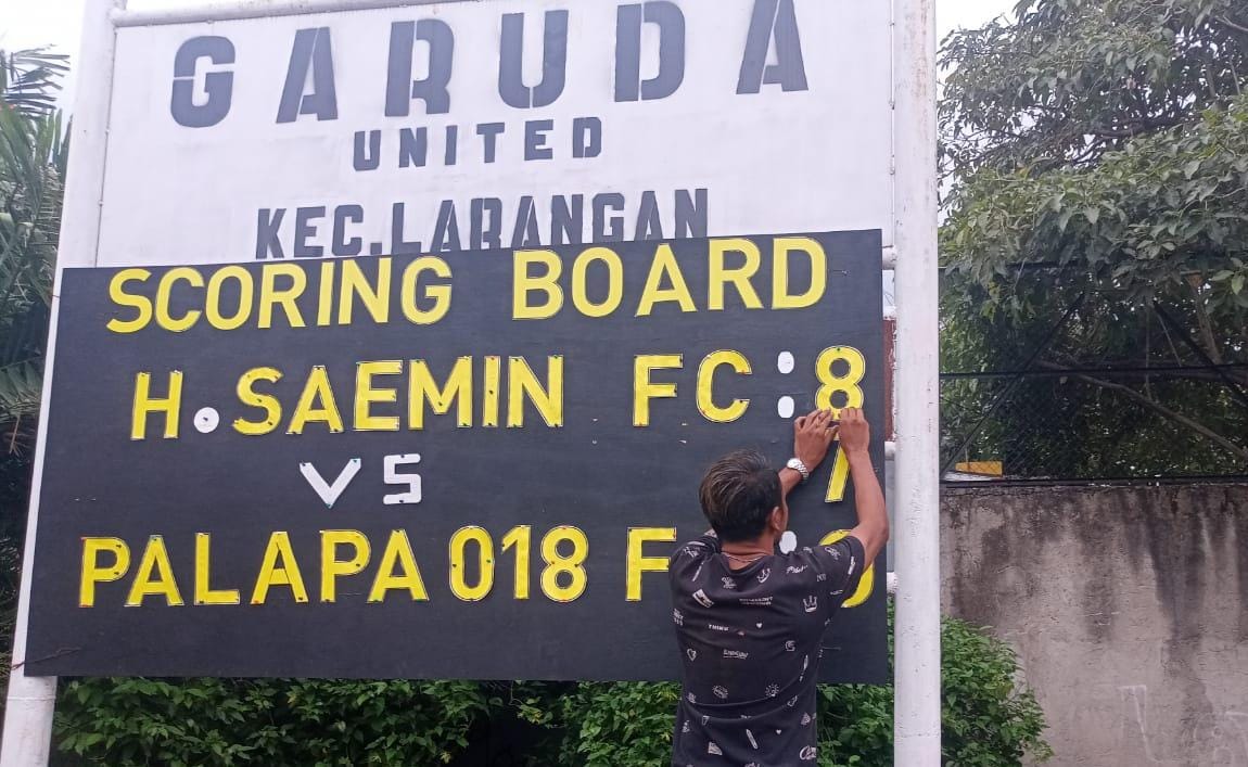 Panitia yang bertugas di papan skor sedang mengganti angka 7 dengan angka 8 untuk H Saemin FC. H Saemin mampu mengatasi Palapa FC, 8-0.(Foto:Red/tangselpos.id).