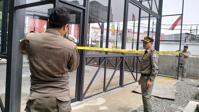 Patugas Pol PP Kota Tangsel melakukan pejyegelan terhadap bangunan di Serua, Ciputat, Selasa (5/12).(dra)