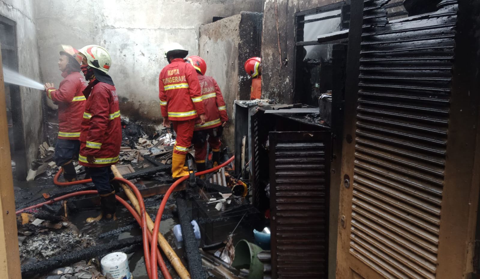 Petugas pemadam kebakaran terlihat tengah melakukan pemadaman di satu unit rumah di Kecamaran Pondok Aren.(Dra)