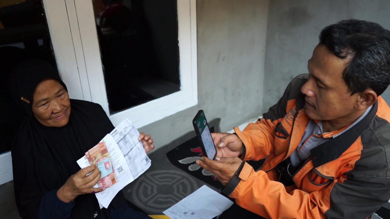 Penyaluran Bansos PKH Di Tangsel Capai 93% Petugas Pos sedang membagikan Bansos ke warga, Kamis (2/5).(dra)