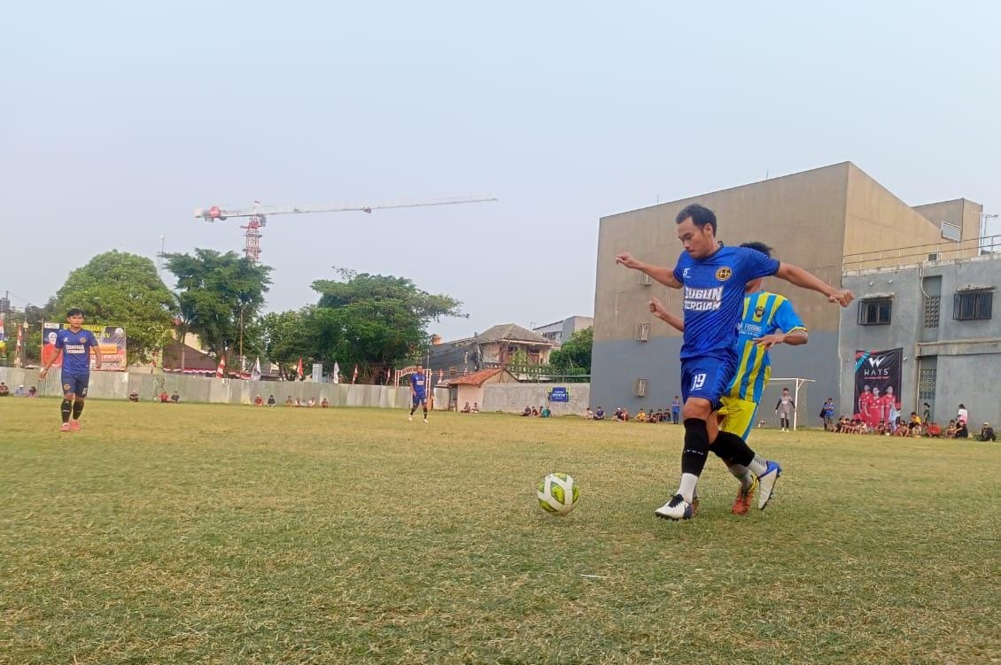 Satya Muda Relakan Harpas Rebut Tiket 16 Besar, Tim Era 80-an Tampil Fight Hadapi Nayla B Bek Harpas FC, Faisal (biru) menguasai bola dibayangi pemain Satya Muda.(ist).