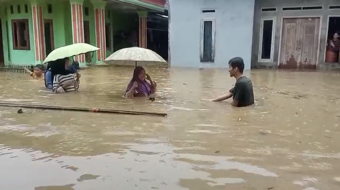 Banjir Kepung 7 Kecamatan Di Pandeglang Warga Kampung Cikayas, Desa Cikayas, Kecamatan Angsana, sedang menerobos banjir untuk melakukan pengungsian ke wilayah yang tidak banjir, Senin (26/5).