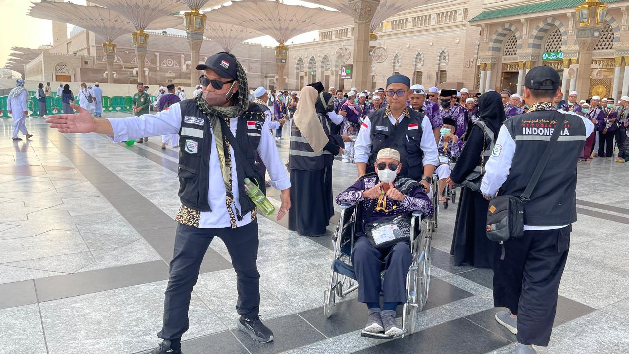 Haji 2025 Petugas Haji saat mendorong kursi roda jamaah haji. Foto : Ist
