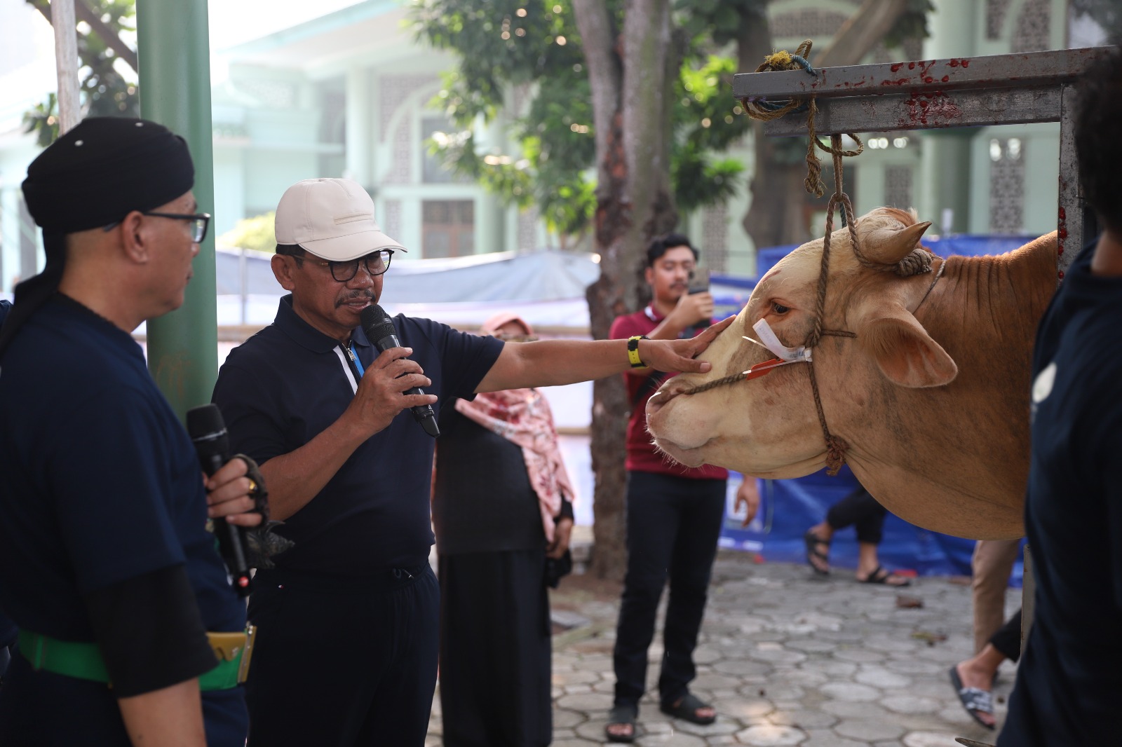 5.000 Paket Daging Dibagikan ke Masyarakat Wali Kota Tangerang, Sachrudin tampak sedang berdoa sambil memegang salah satu hewan kurban sebelum disembelih oleh panitia di Masjid Raya Al-A’zhom, Kota Tangerang, Sabtu (7/6).