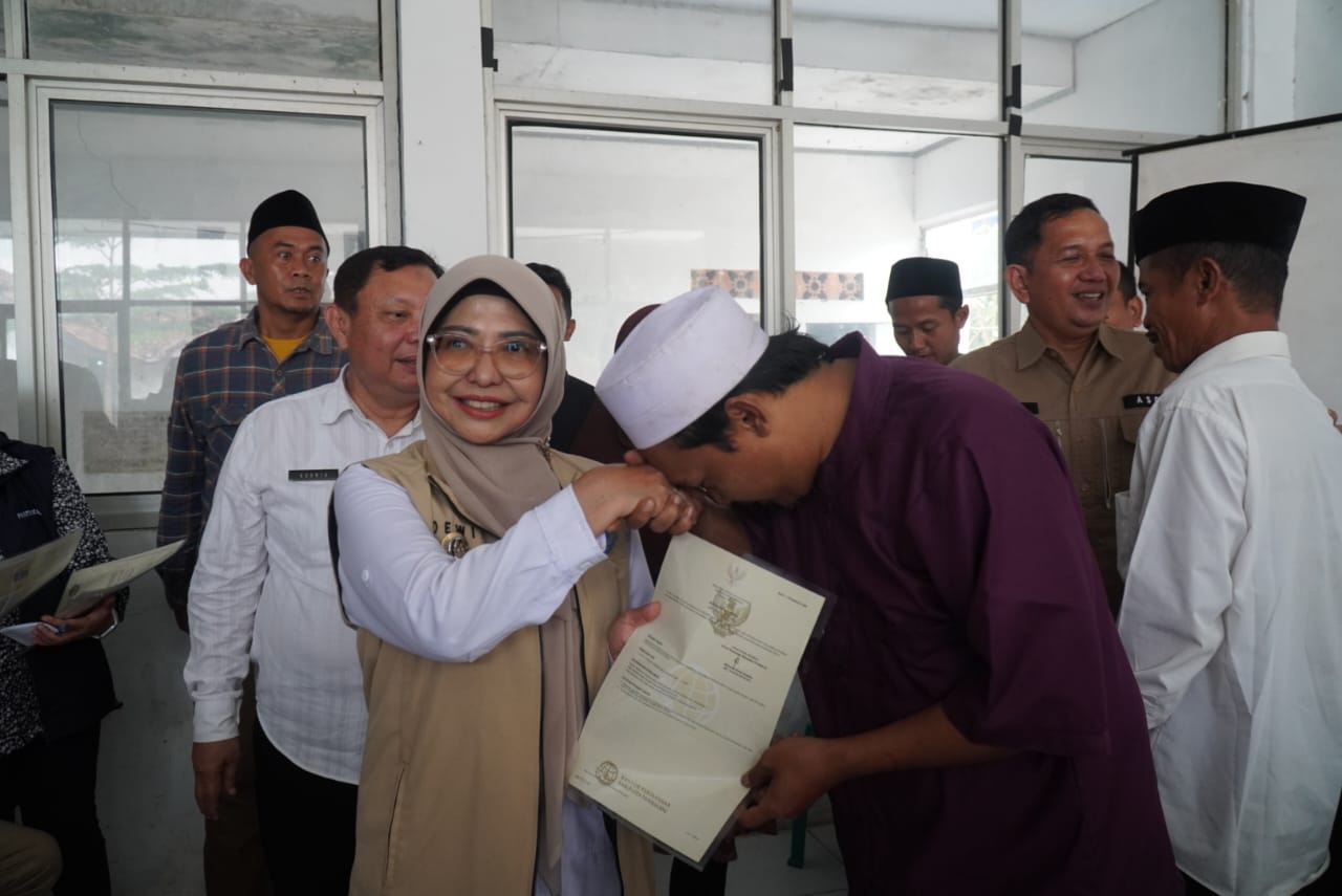 Bupati Dewi Bakal Basmi Mafia Tanah Bupati Pandeglang, Raden Dewi Setiani sedang menyerahkan sertifikat tanah program PTSL kepada warga Desa Ciburial, Kecamatan Cimanggu, di Aula Kantor Camat Cimanggu, beberapa waktu.