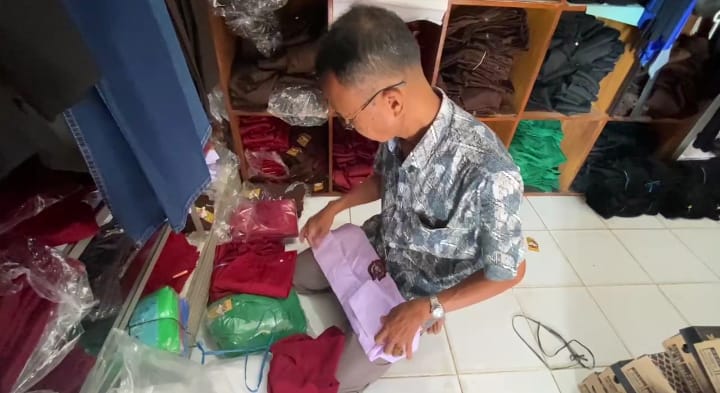 Salah seorang penjual perlengkapan sekolah di Pasar Sampay, Kecamatan Warunggunung, Kabupaten Lebak, sedang merapikan dagangannya, Rabu (2/7).