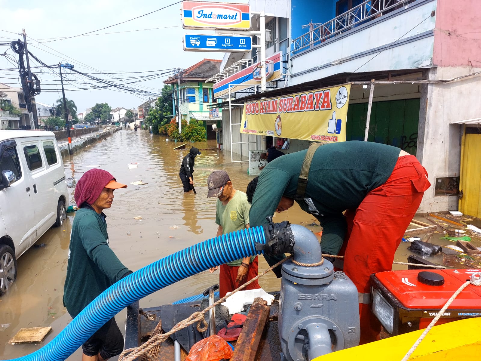 Petugas saat mengoperasikan pompa air di lokasi banjir Pondok Maharta, Selasa (8/7).