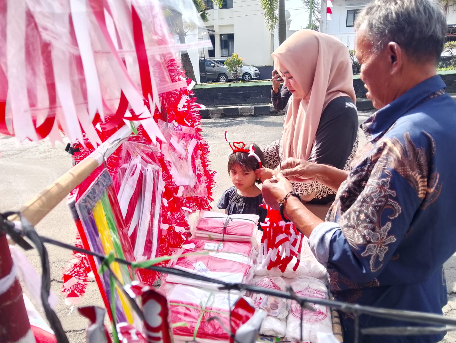 Salah seorang pedagang bendera Merah Putih di pinggir Jalan Raya Serang-Pandeglang, tepatnya di samping kantor Kodim Pandeglang, sedang melayani pembeli, Selasa (5/8).