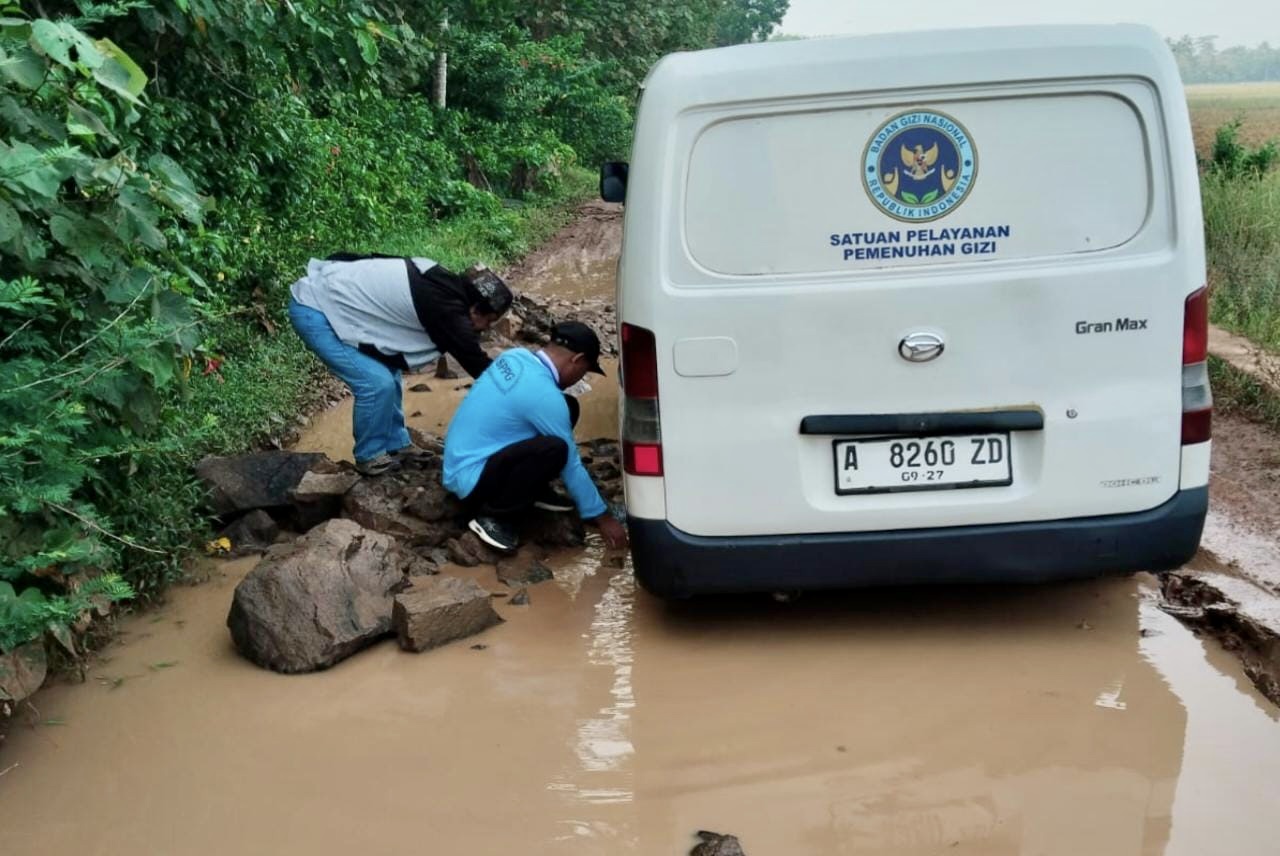 Pihak Tim Distribusi MBG Yayasan Cahaya Anagata Nusantara SPPG Sindanglaya 2, sedang berupaya berbagai cara agar kendaraan yang digunakannya bisa melintas di jalan rusak, dan sampai ke sekolah tepat waktu.