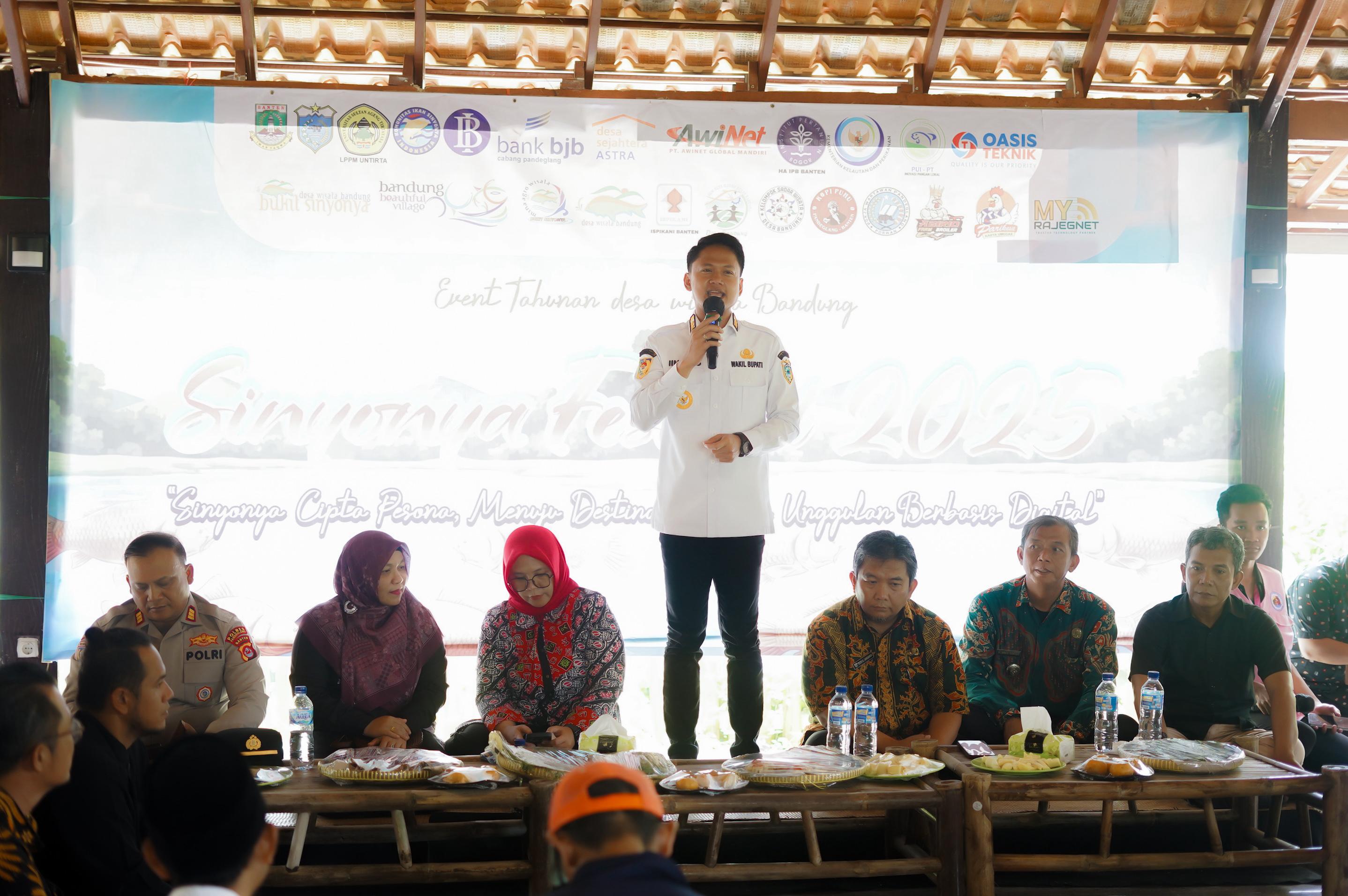 Pemdes Bandung Lestarikan Budidaya Ikan Mas Sinyonya Lewat Festival Wabup Pandeglang, Iing Andri Supriadi sedang memberikan sambutan di acara Sinyonya Festival 2025, di Mina Agro Wisata Bukit Sinyonya, Desa Bandung Kecamatan Banjar, Kamis (30/10)