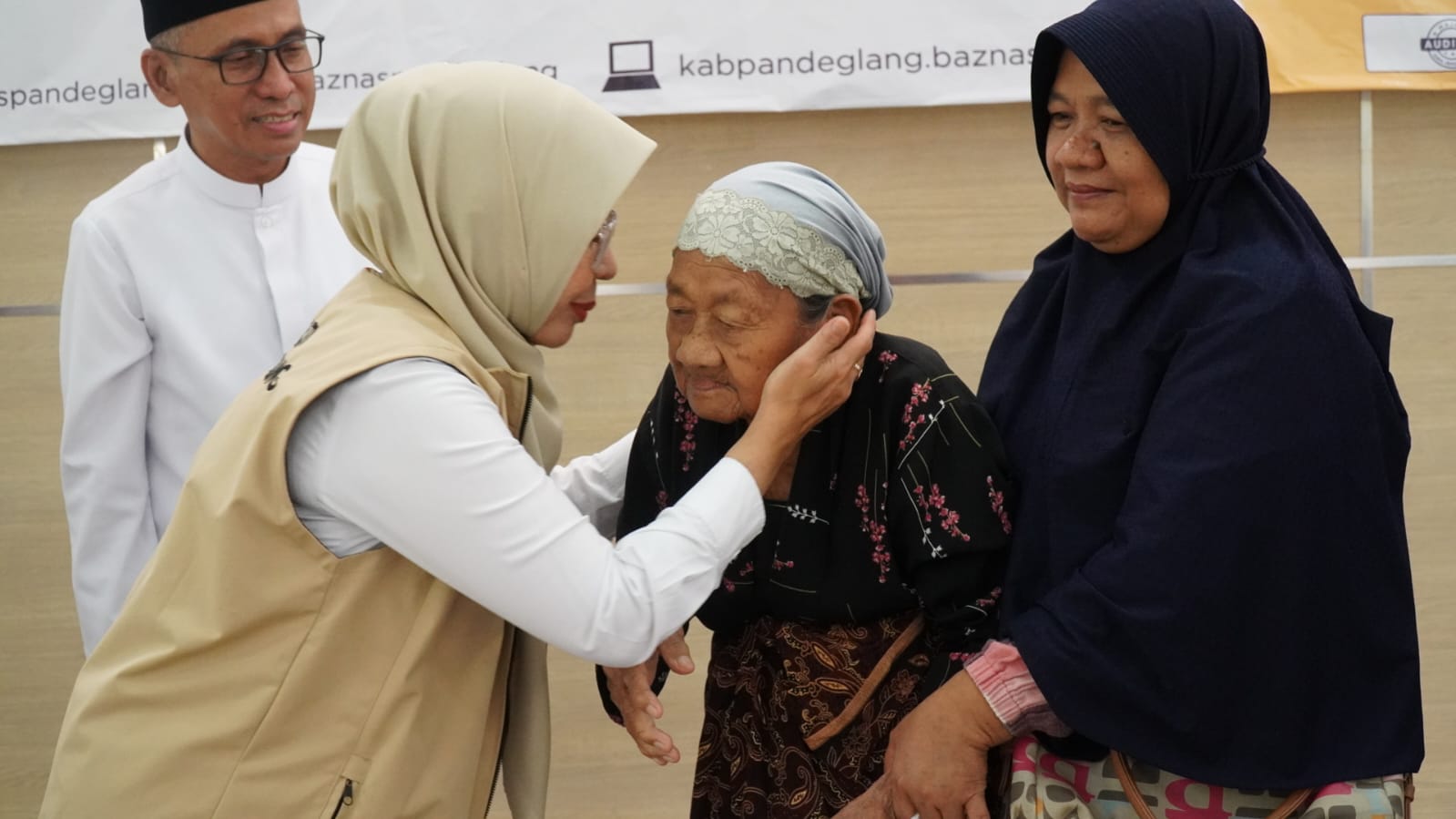 Bupati Raden Dewi Setiani mencium warga yang mendapatkan bantuan rumah laka huni dari Baznas RI.(Istimewa)