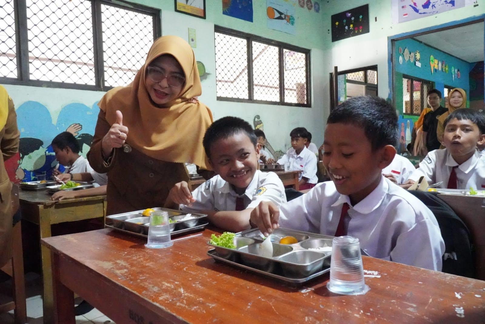 Bupati Pandeglang Raden Dewi Setiani, sedang foto bersama dengan para siswa saat hendak menyantap MBG di salah satu sekolah di Pandeglang, beberapa waktu lalu.