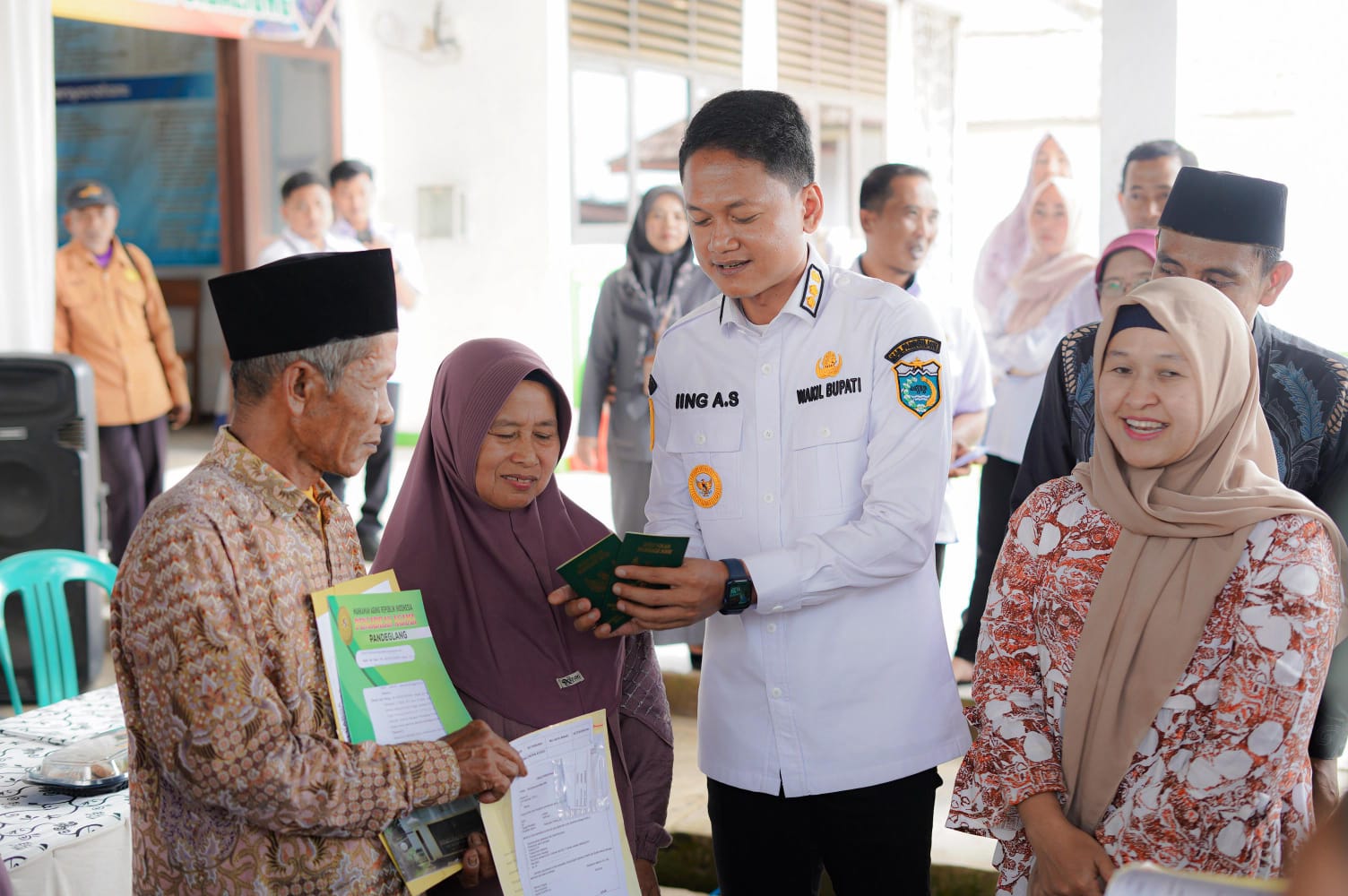 Wabup Iing Andri Supriadi memberikan buku nikah kepada pasangan suami istri yang mengikuti Isbat Nikah Terpadu, di Kecamatan Cibaliung, Rabu (26/11/2025).(Istimewa)