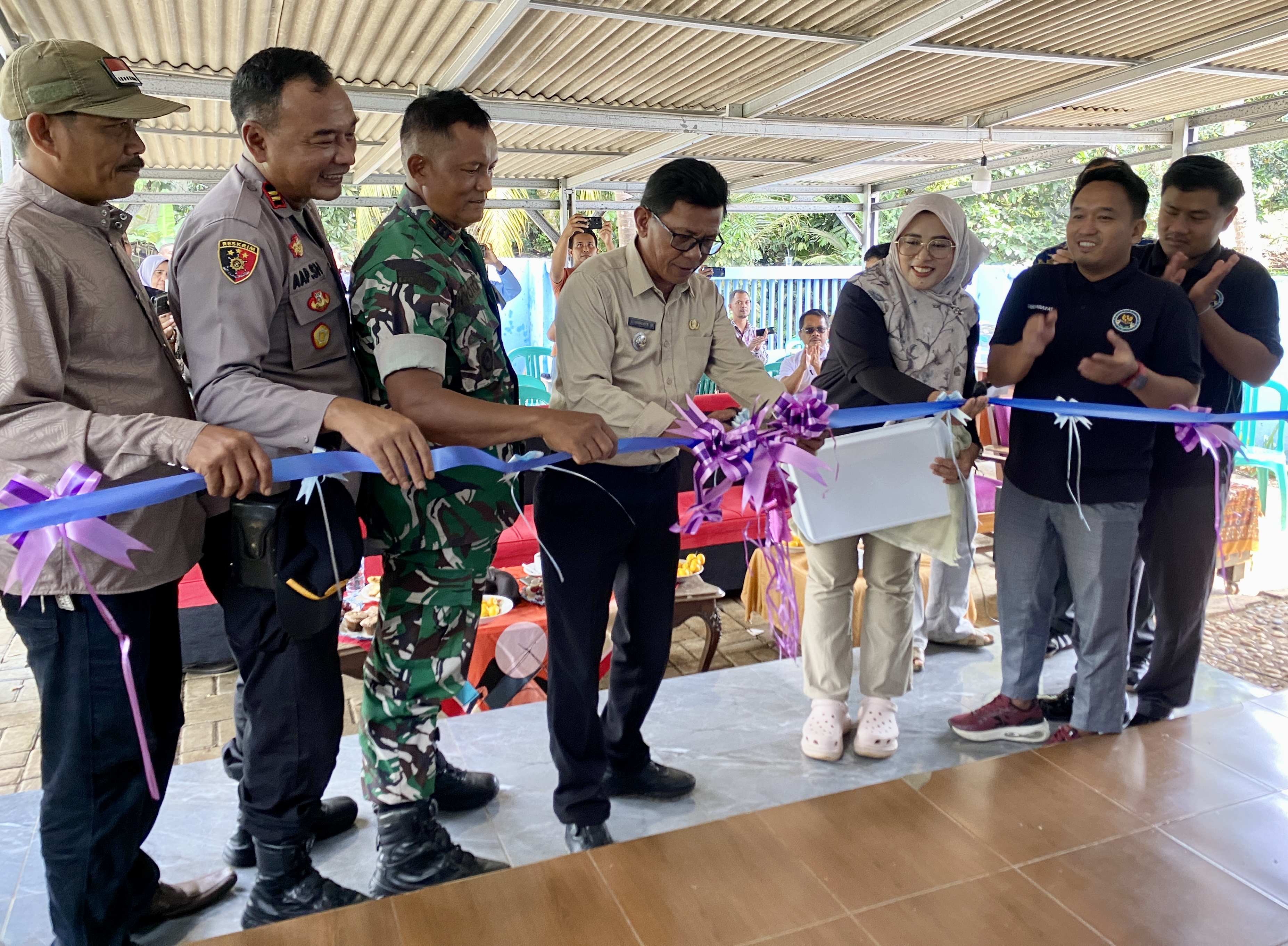 Camat Mekarjaya Ahmad Jamaludin didampingi Kapolsek, Danramil dan pihak SPPG Mekarjaya 01, sedang menggunting pita sebagai simbolis meresmikan SPPG Mekarjaya 01 di Kampung Pasir Tenggek RT/RW 012/004, Desa Kadubelang, Kecamatan Mekarjaya, Kabupaten Pandeglang, Minggu (7/12).