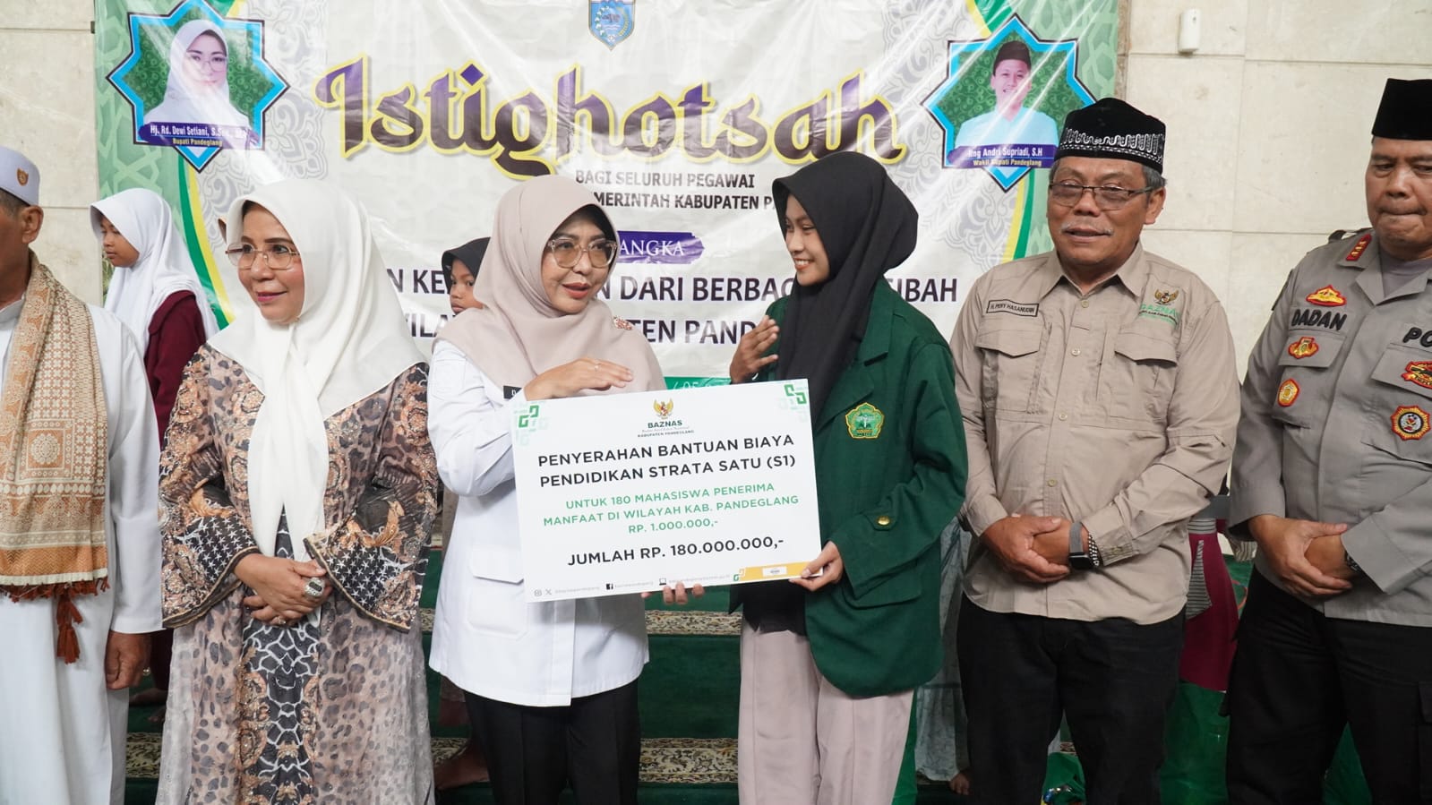 Bupati Dewi Setiani menyerahkan bantuan pendidikan kepada mahasiswa, di sela-sela kegiatan istigasah di Masjid Agung Ar-Rohman, Pandeglang, Rabu (24/12/2025).(Istimewa)