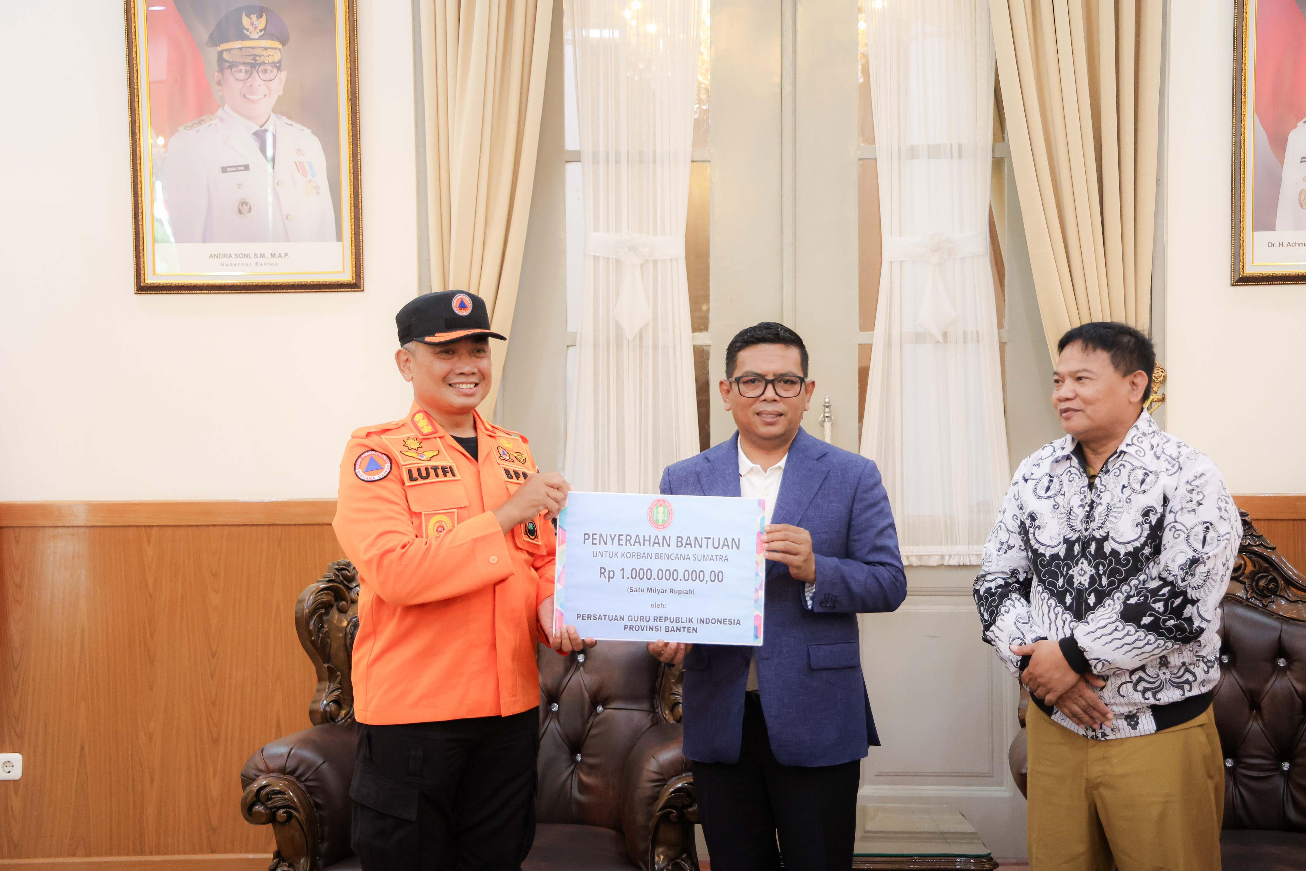 Ketua PGRI Provinsi Banten Jamaluddin (kanan) menyerahkan bantuan kepada Gubernur Andra Soni (tengah) di Gedung Negara Provinsi Banten. Foto : Humas Pemprov