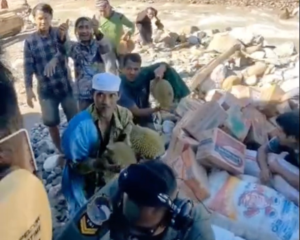 Warga memberikan durian kepada petugas yang mengantarkan bantuan. Foto : Tim Media Presiden