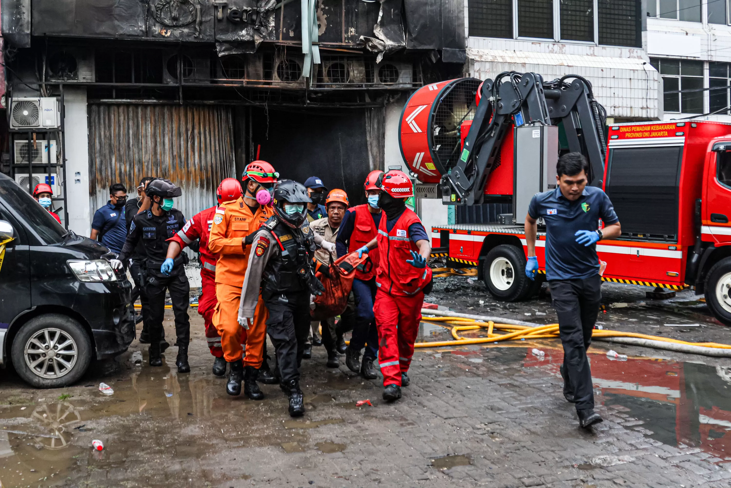 Petugas sedang mengevakuasi korban kebakaran gedung Terra Drone. Foto : Ist