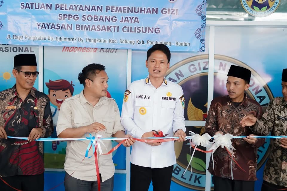 GUNTING PITA. Wabup Pandeglang Iing Andri Supriadi didampingi para pihak lainnya, sedang meresmikan SPPG MBG Sobang Jaya, Kecamatan Sobang, Kabupaten Pandeglang, secara simbolis dengan menggunting pita, beberapa waktu lalu