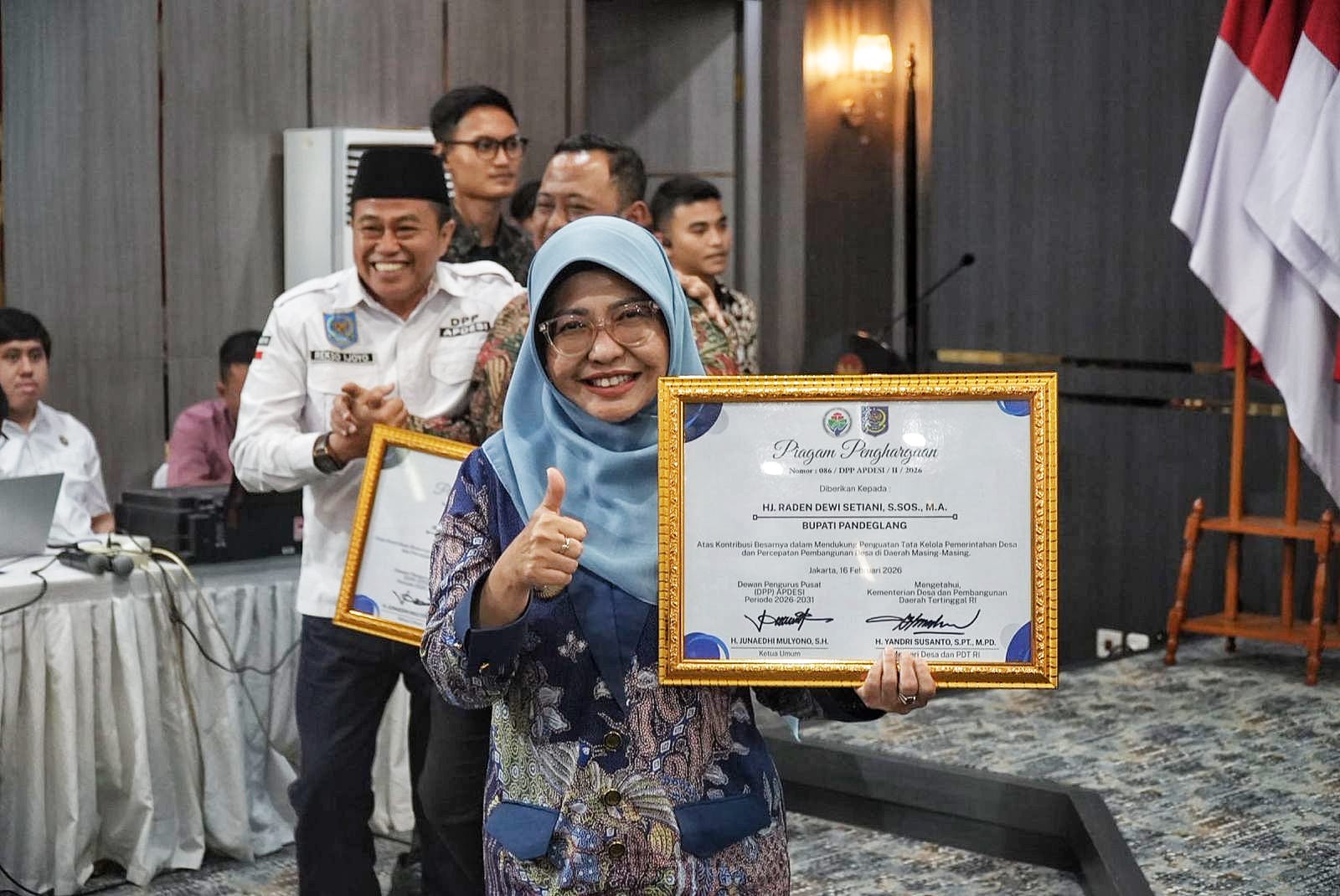 Bupati Dewi Setiani menunjukkan piagam penghargaan dari Kemendesa PDT.(Istimewa)