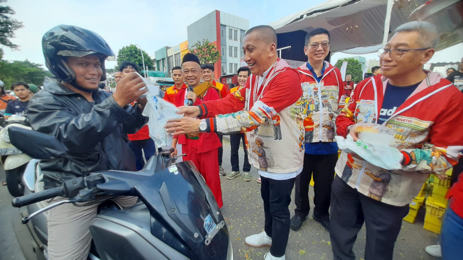 Corporate Affairs Director Alfamart Solihin (tengah) saat membagikan paket berbuka gratis kepada pengendara jalan. Foto : Irawan/TP