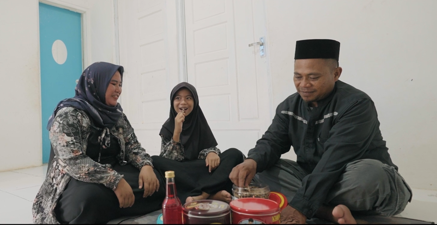 Warsana dan keluarga menikmati rumah barunya. Foto : Ist