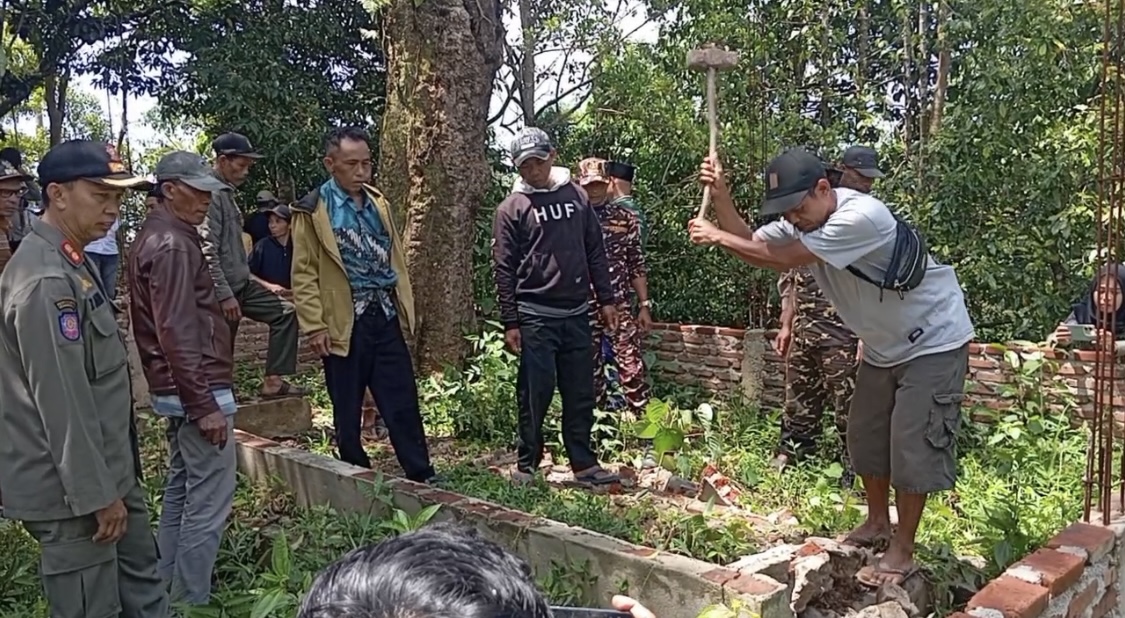 Warga bersama aparat setempat sedang membongkar makam keramat yang diduga palsu di Kampung Jaura, Desa Panjangjaya, Kabupaten Pandeglang, Senin (30/3).