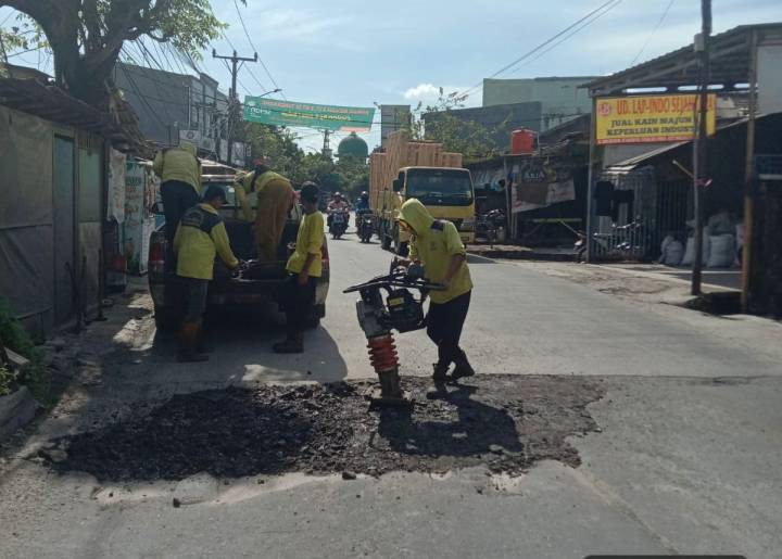 Petugas Dinas Pekerjaan Umum dan Penataan Ruang (DPUPR) Kota Tangerang memperbaiki jalanan rusak di sepanjang Jalan Raya Kutabumi-Periuk.