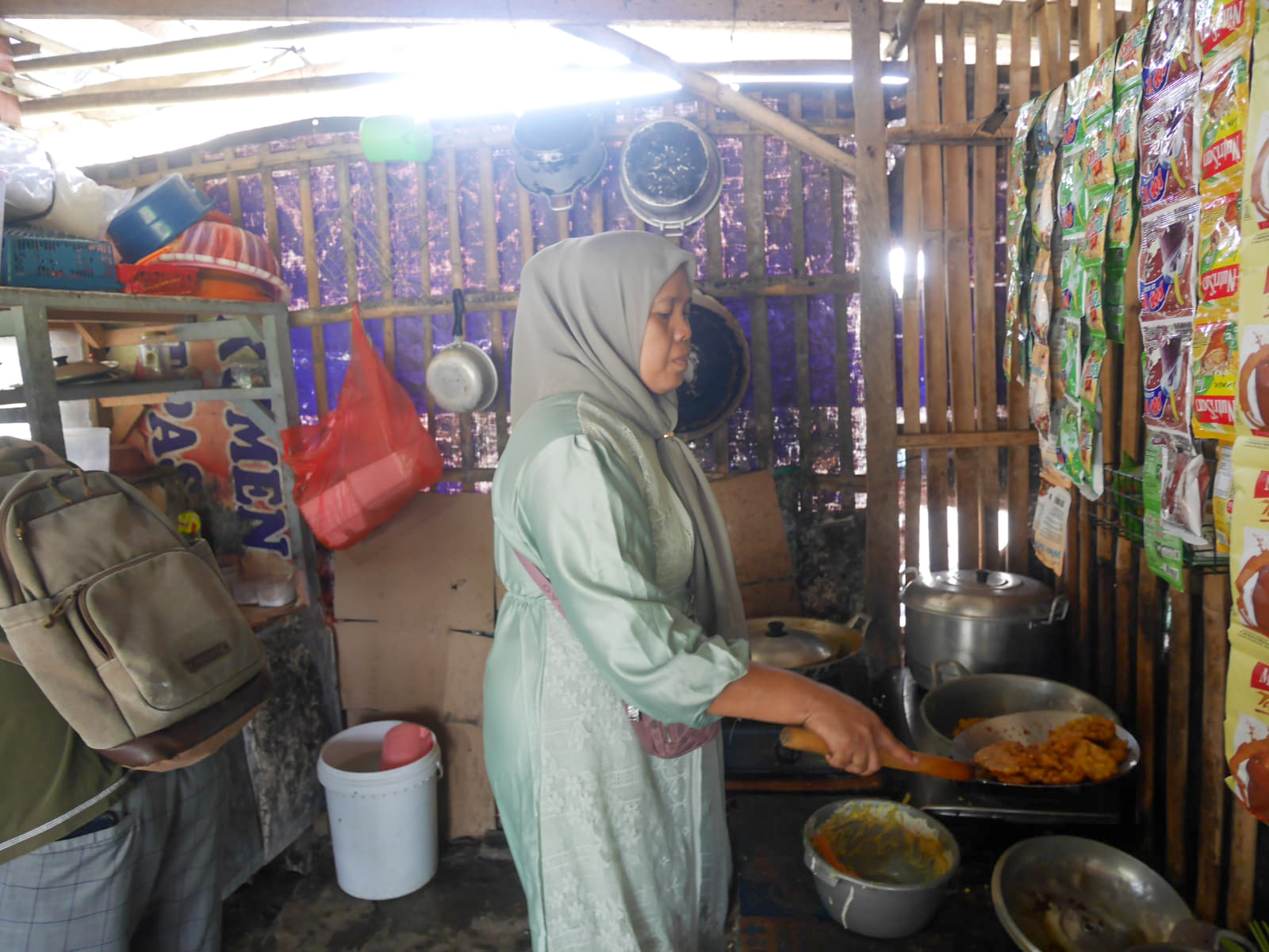 Ibu Sumi (47), tengah memasak di warungnya yang berada di seberang Puspemkot Serang, Selasa (21/4/2026).(Istimewa)