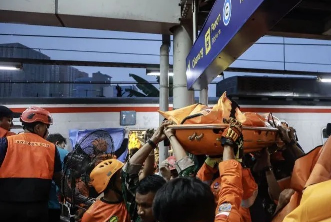 Petugas gabungan sedang mengevakuasi korban kereta. Foto : Ist