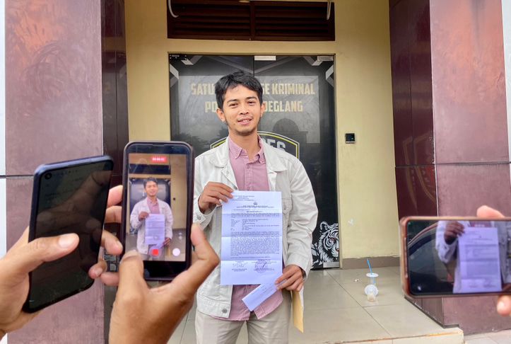 BUKTI LAPORAN. Anggota DPRD Pandeglang dari Fraksi Golkar, Miftahul Farid Sukur, sedang diwawancara wartawan sambil menunjukan bukti melaporkan oknum pengusaha konstruksi ke polisi, di halaman Mapolres Pandeglang, Rabu (6/5). (NIPAL SUTIANA/TANGSEL POS)