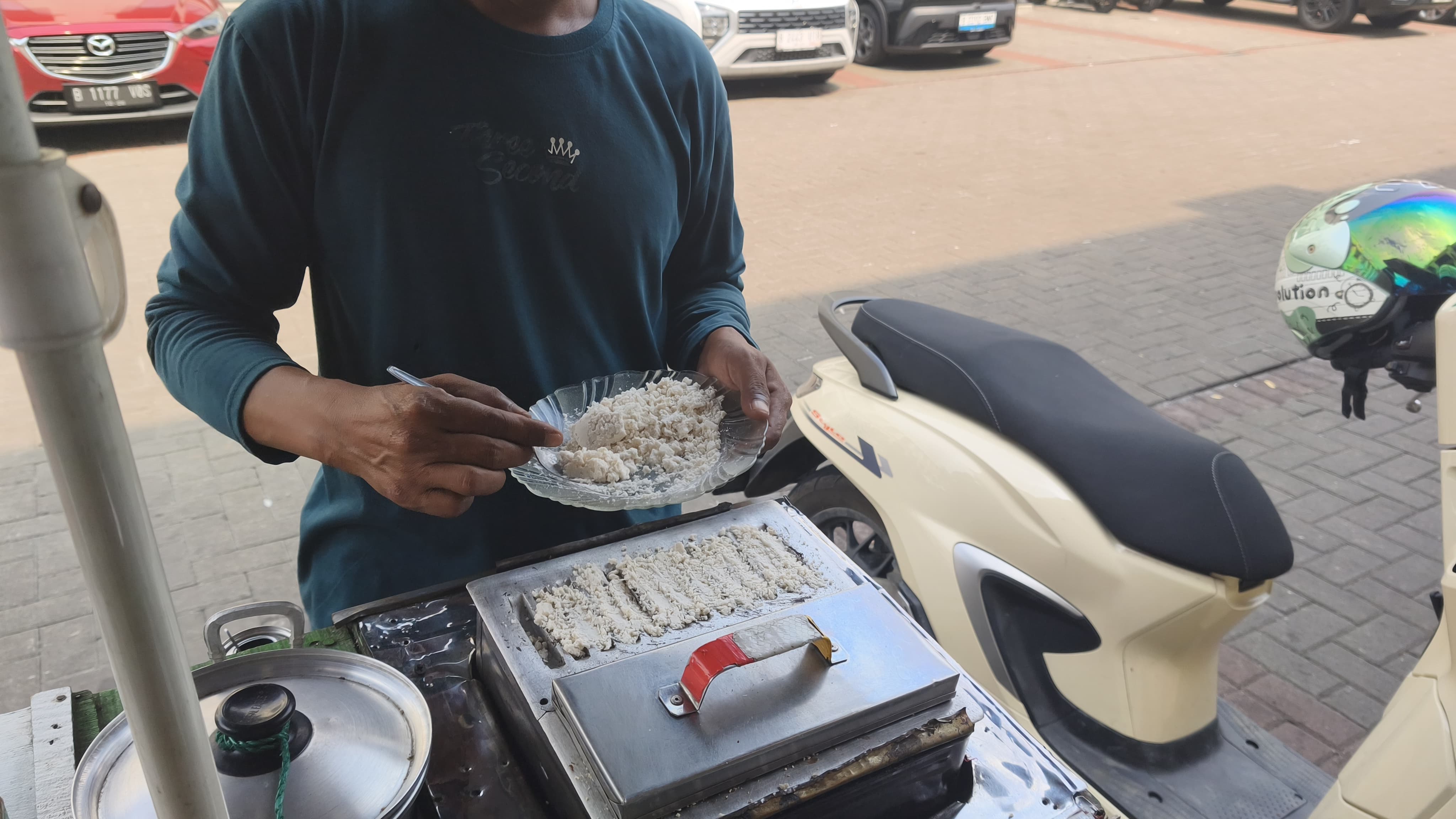 Pak Eko memanggang kue rangi yang dibuat dari campuran sagu dan kelapa parut untuk pelanggan di gerai Kue Rangi Eka, Gading Serpong. Foto : Ist