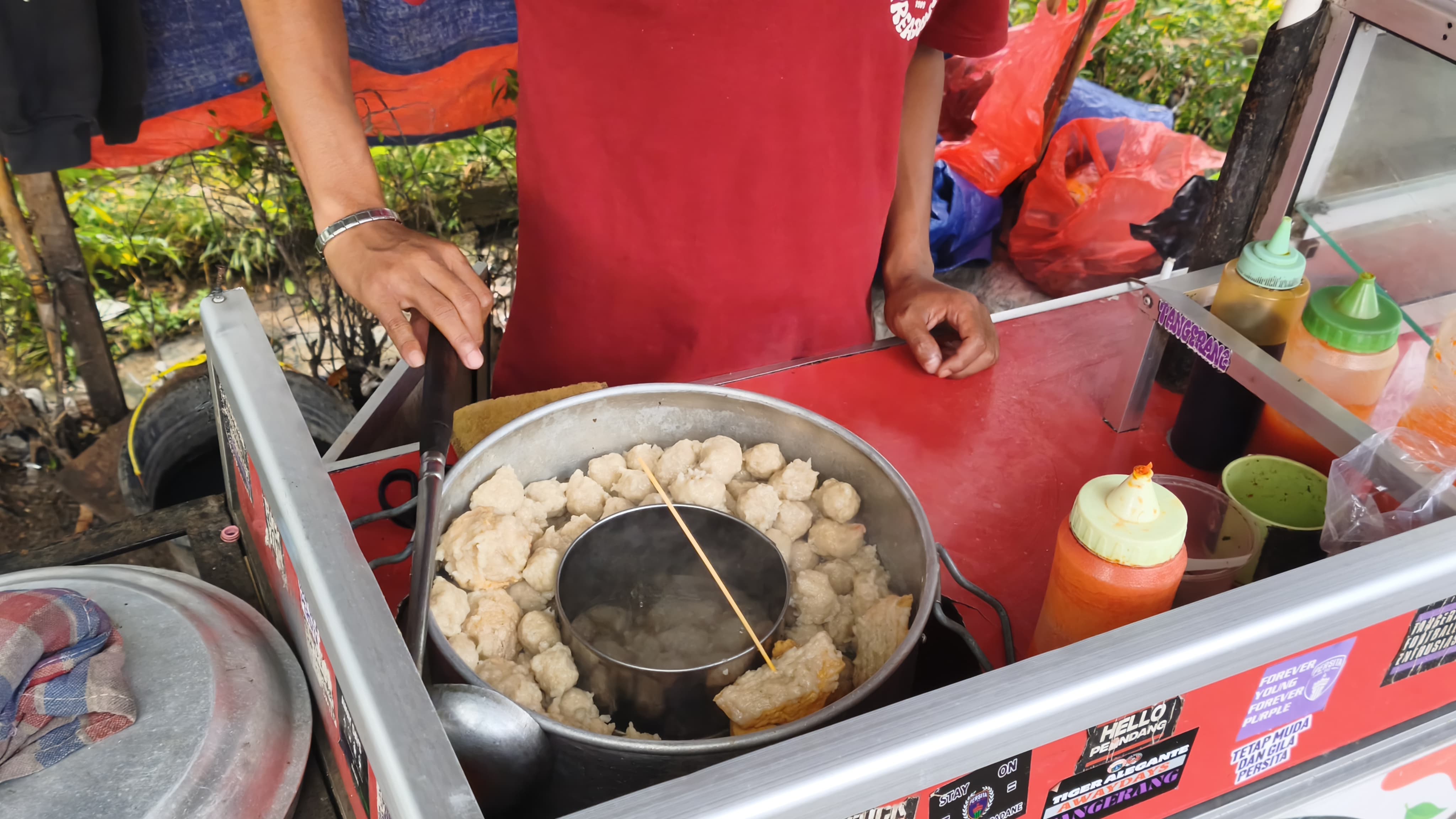 Muhammad Abdu menyiapkan pesanan Cilok Urat Baradax di kawasan Kelapa Dua, Tangerang. Jajanan kaki lima yang menawarkan pilihan cilok kuah maupun kering ini mampu menjual ratusan porsi setiap hari dan menjadi salah satu kuliner favorit warga sekitar. Foto : Ist