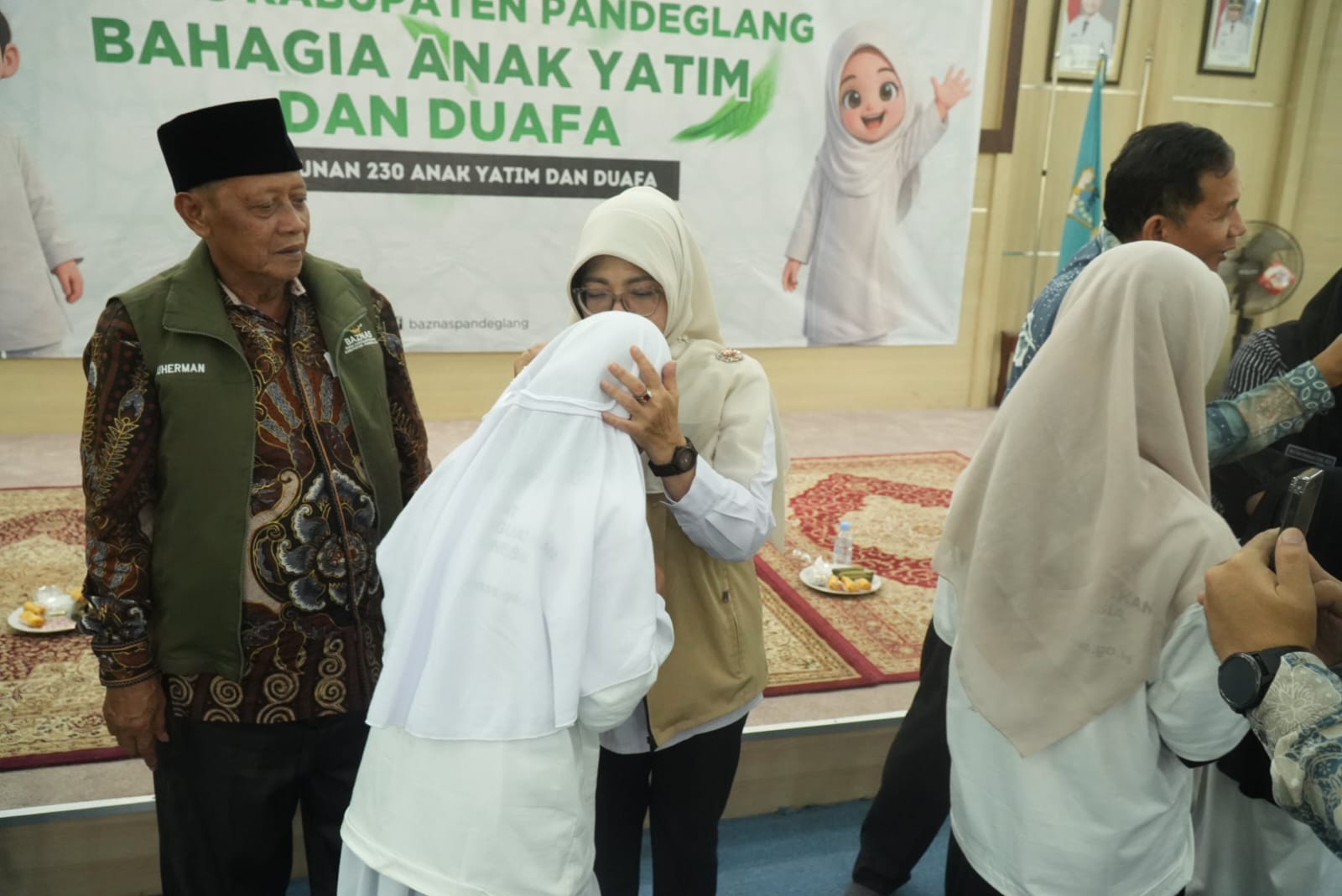 Bupati Raden Dewi Setiani mencium yatim saat menyerahkan santunan dalam acara Gebyar 10 Muharam, di Aula Pendopo Pandeglang, Kamis (25/6/2026).(Istimewa)