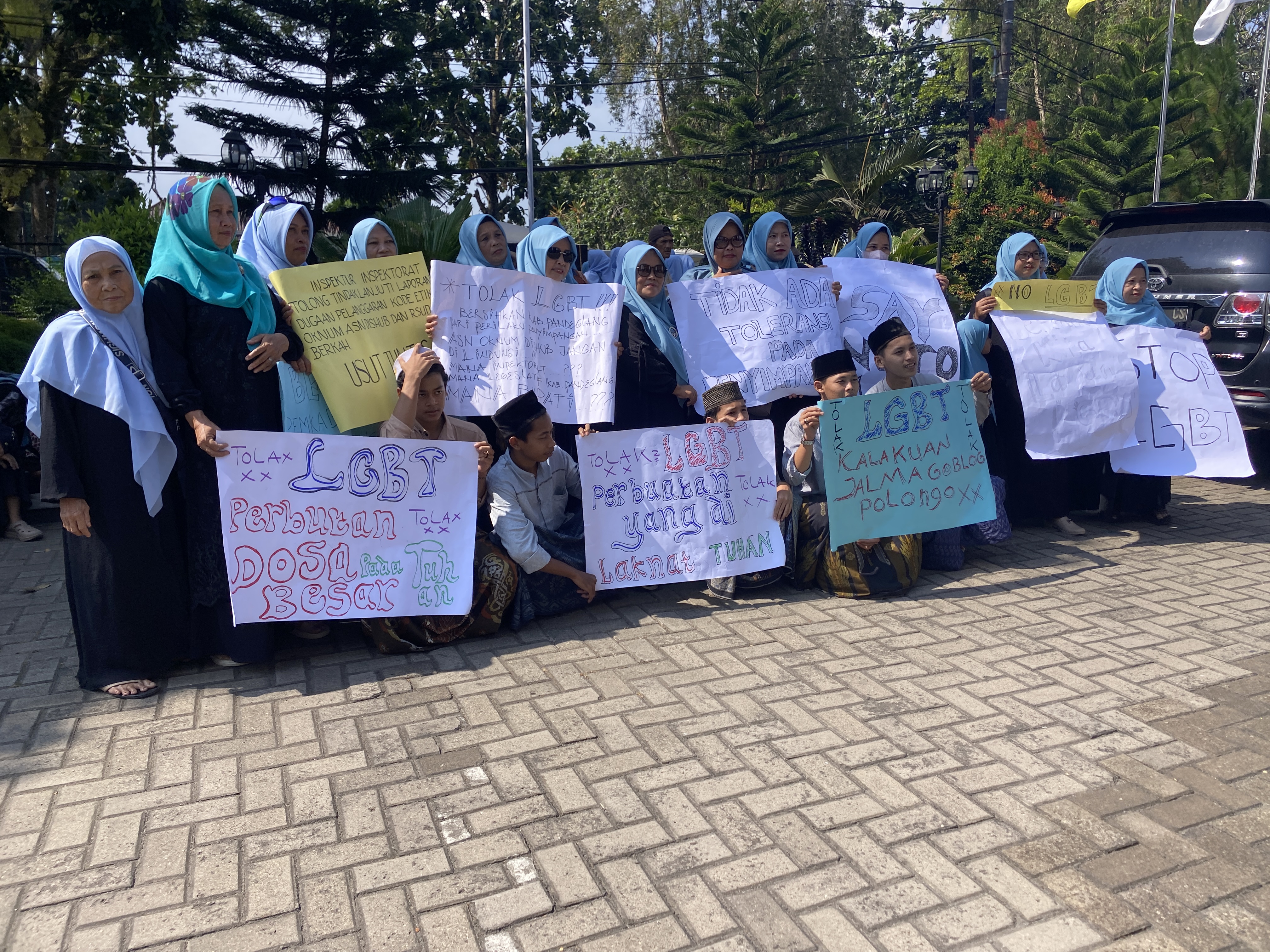 TOLAK LGBT. Para santri dan masyarakat Kabupaten Pandeglang, sedang membentangkan poster kecaman menolak keberadaan LGBT, di Halaman Kantor DPRD Kabupaten Pandeglang, Rabu (22/7). (NIPAL SUTIANA/TANGSEL POS)