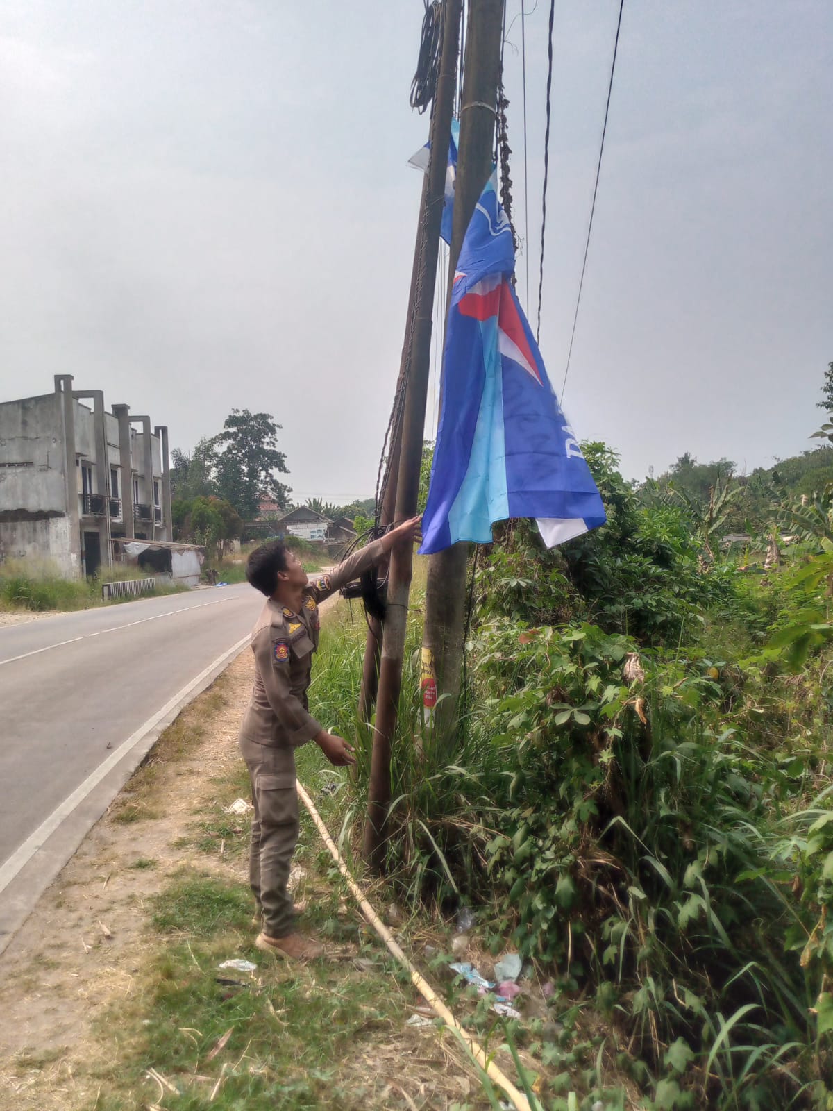 Petugas Satpol PP melakukan penertiban bendera Partai Demokrat di di Jalan Syekh Moh. Nawawi Al Bantani, Kota Serang, Jumat (31/7/2026).(Ari Supriadi-tangselpos.id)