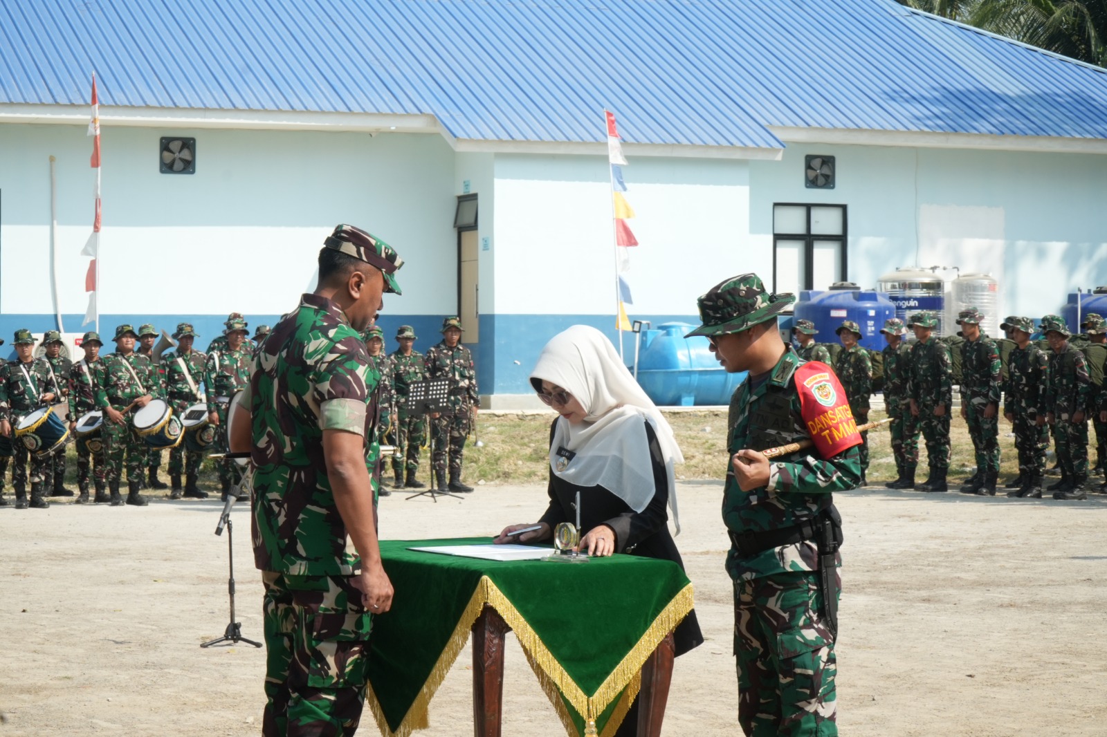TANDATANGANI. Bupati Pandeglang Raden Dewi Setiani, di hadapan Danrem 064/Maulana Yusuf Brigjen TNI Daru Cahyadi Soeprapto, dan didampingi Dandim 0601/Pandeglang, Letkol Inf. Afri Swandi Ritonga, hendak menandatangani berita acara TMMD) ke-129 TA 2026, di Lapangan Kecamatan Patia, Rabu (15/7). (DOK. PROKOPIM SETDA PANDEGLANG)