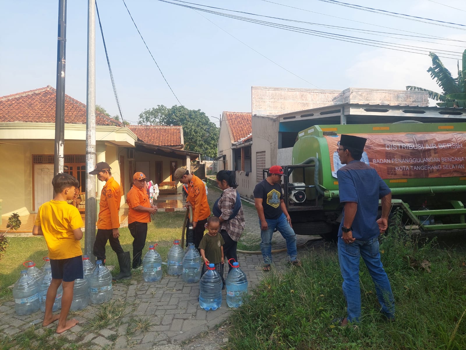 KEKERINGAN. Warga Keranggan, Kecamatan Setu saat mengambil air bersih yang didistribusikan oleh BPBD Tangsel, Senin (13/7).